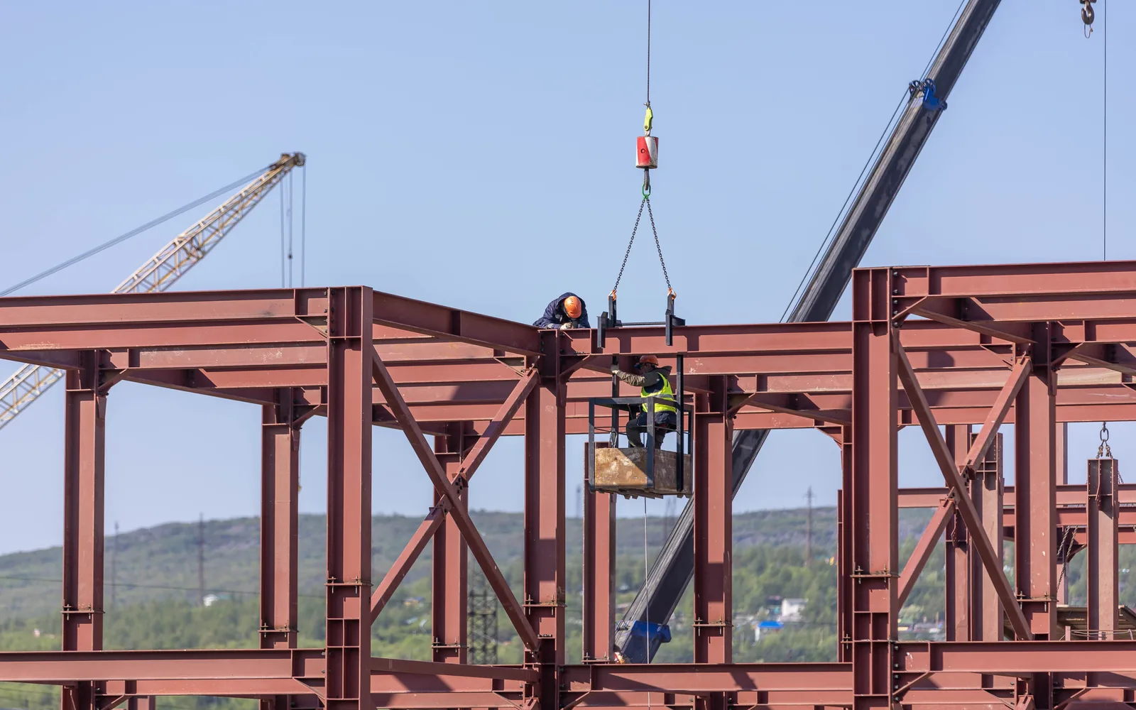 Workers assembling a steel building frame